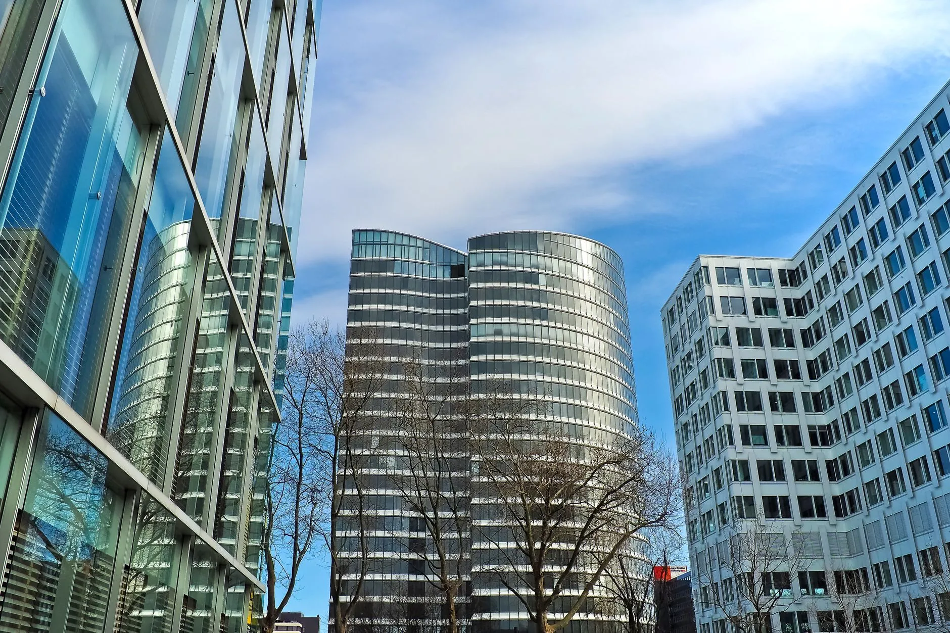 Glass-and-steel corporate office towers viewed from street level against a clear sky