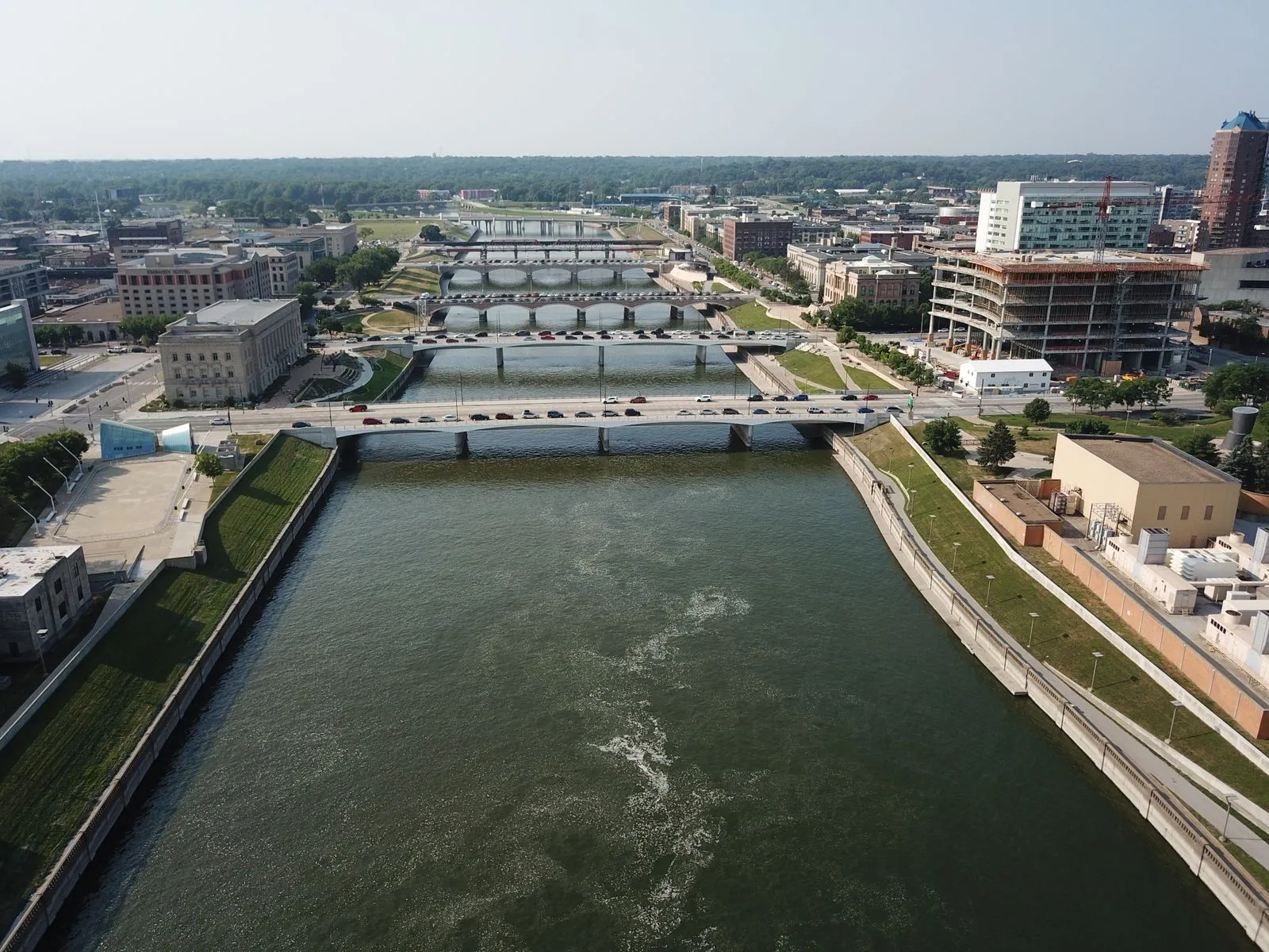 A river running straight through a city under a series of low bridges, seen from above